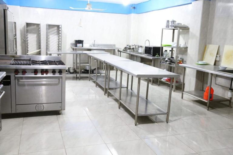 Área de cocina con estufa y mesas de acero inoxidable en el laboratorio de nutrición de CEUSJIC